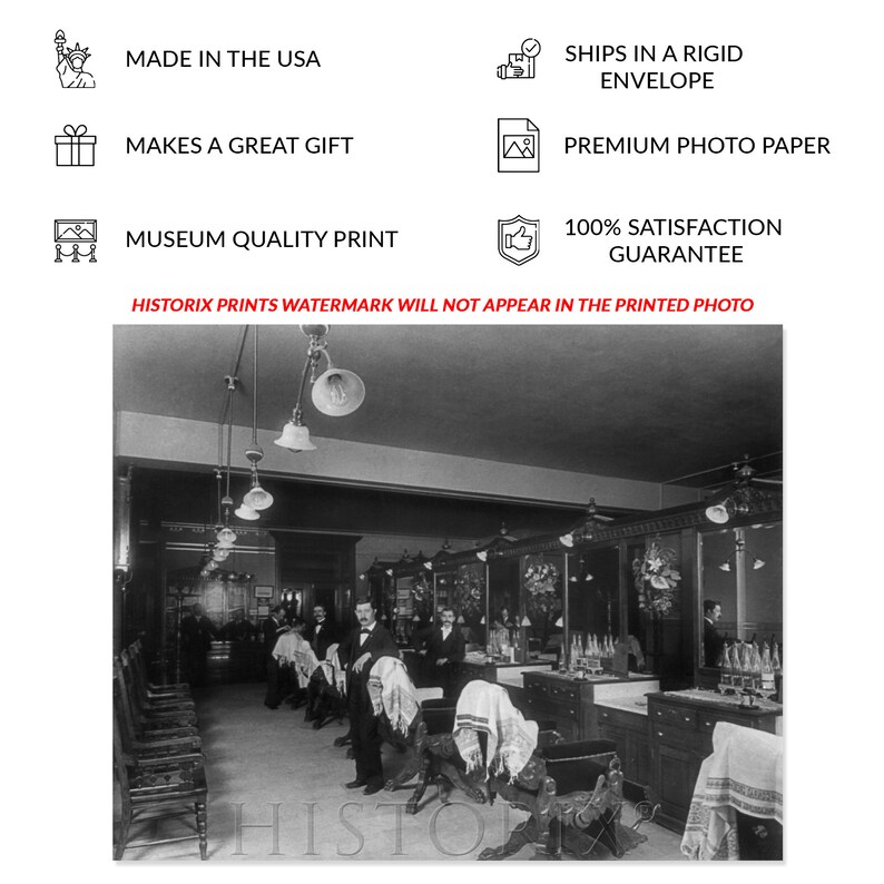 May include: Black and white photograph of a barbershop interior. The barbershop has multiple barber chairs, mirrors, and a counter with bottles of hair products. The photo was taken in the early 1900s.
