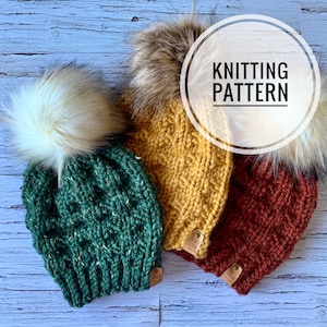 May include: Three knitted hats with faux fur pom poms. The hats are green, yellow, and brown. The hats have a cable knit pattern. The hats have a leather tag with the text "Cozy Cole" on them.  KNITTING PATTERN.
