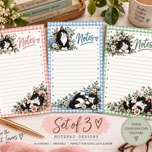 May include: A set of three rectangular notepads featuring a black and white cat illustration, floral accents, and the word Notes. Each notepad has a different colored gingham border in pink, blue, or green, with horizontal lines for writing.