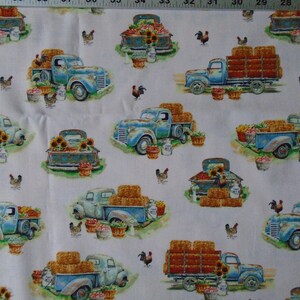May include: A white fabric with a repeating pattern of blue pickup trucks carrying hay bales, vegetables, and sunflowers. The trucks are surrounded by chickens and roosters.