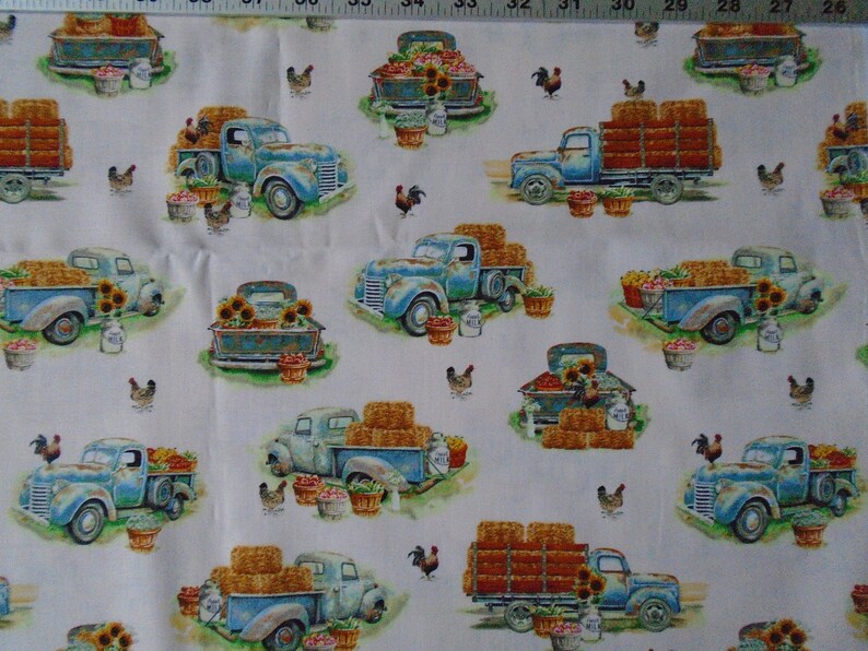 May include: A white fabric with a repeating pattern of blue pickup trucks carrying hay bales, vegetables, and sunflowers. The trucks are surrounded by chickens and roosters.