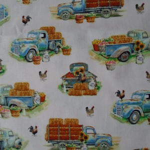 May include: A white background with a repeating pattern of blue vintage pickup trucks carrying bales of hay, sunflowers, and baskets of produce. The trucks are on a white background with a green grassy area around the wheels. There are also chickens and roosters in the pattern.