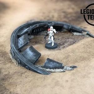 May include: A grey, 3D printed, half-circle shaped terrain piece with a textured surface. The piece is broken into several sections. A white, plastic miniature of a stormtrooper stands on a black base in front of the terrain piece.