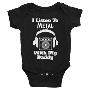 May include: Black baby onesie with white text that reads "I Listen To METAL With My Daddy" and a graphic of a guitar amplifier with headphones.