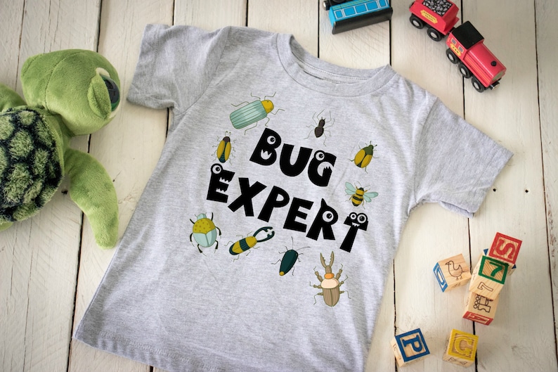 May include: A gray t-shirt with a black graphic that says "Bug Expert" surrounded by colorful cartoon bugs.