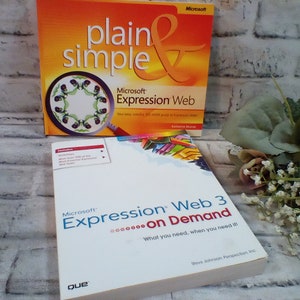 May include: Two books about Microsoft Expression Web. The top book has a red cover with the text "plain simple" and "Microsoft Expression Web". The bottom book has a white cover with the text "Microsoft Expression Web 3 on Demand" and "What you need, when you need it!"
