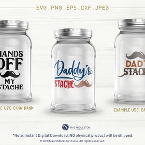 以下が含まれることがあります： 「Hands Off My Stache」、「Daddy's Stache」、「Dad's Stache」と書かれたラベルが付いたガラス製の瓶が3つあります。瓶は木製の背景の上に置かれています。ラベルは黒、赤、青、茶色です。