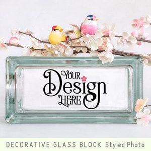 May include: A decorative glass block with a white background and the text "Your Design Here" in black calligraphy. The block is surrounded by pink cherry blossoms.