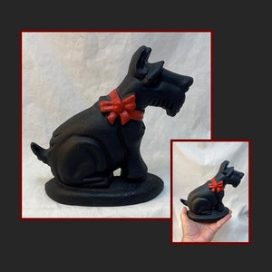 Gietijzeren Schotse terriër met rode strikdeurstopper. Scotty Dog-sculptuurbeeldje. Omstreeks 1950.