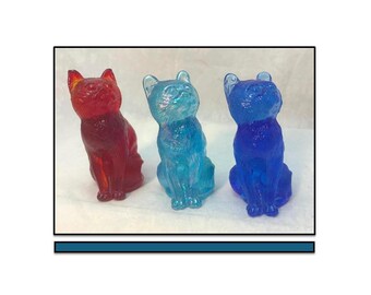 Drie zittende Mosser-katten, drie mal 101 katten in robijnrood, kobaltblauw en iriserend blauw, beeldjes van 3 inch