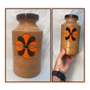 May include: A brown ceramic vase with a textured surface and a stylised orange and black flower design.