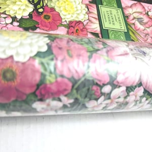 May include: Rolled drawer liners featuring a floral design with pink, white, and yellow flowers. The liners have a green border with the word "PLUMERIA" printed on them. The overall theme is floral and decorative.