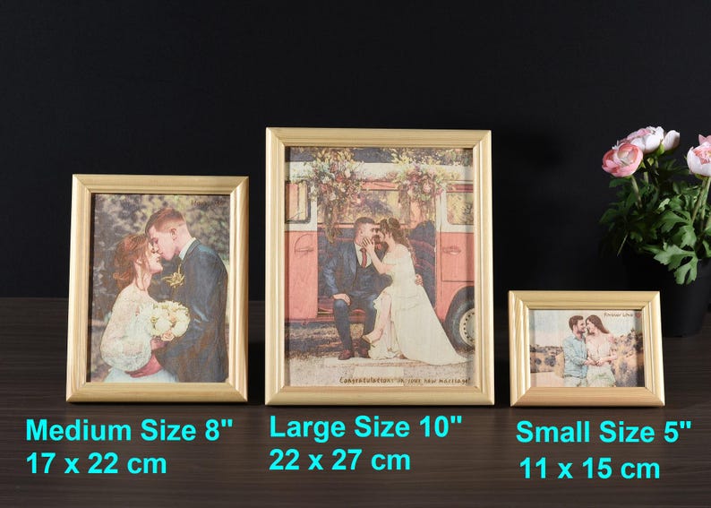 May include: Three gold picture frames with different sizes. The frames are on a wooden surface. The largest frame is 10 inches and shows a couple in front of a vintage van. The medium frame is 8 inches and shows a couple kissing. The smallest frame is 5 inches and shows a couple standing in front of a beach.