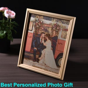 May include: A wooden picture frame with a personalized engraved image of a couple in front of a vintage van. The image is in a cartoon style and the text "Congratulations on your new marriage!" is engraved below the image.