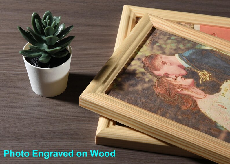 May include: A framed photo of a couple kissing, engraved on a wooden surface. The photo is in a natural wood frame.
