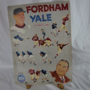 May include: A vintage program for a Fordham vs. Yale football game on October 7, 1950. The program features a photo of the Fordham coach, Herman Hickman, and a depiction of the game in progress. The program is priced at 50 cents.