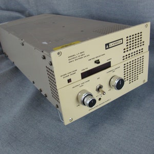 May include: A beige Lambda LT-803 power supply unit with a digital display, knobs, and a switch. The unit has a model number, output voltage, and maximum rating printed on the front.