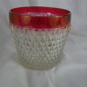 May include: A clear glass bowl with a diamond pattern and a red rim. The bowl is perfect for serving snacks or desserts.