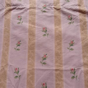 May include: Pink and beige striped fabric with a repeating pattern of small pink roses. The fabric has a subtle texture.