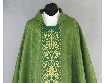 May include: A green liturgical chasuble with gold embroidery featuring a floral design and the inscription "IHS".