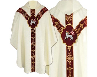 Może przedstawiać: Biała kasel liturgiczna z haftowanym wzorem w kolorze czerwonym i złotym przedstawiającym baranka z chorągwią. Wzór powtarza się na plecach kaseli.