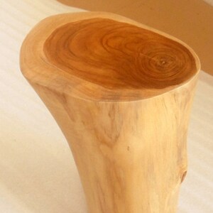 May include: A natural wood stool made from teak with a sanded finish. The stool is 18 inches tall and has a diameter of 7 to 9 inches at the top and 6 to 7 inches at the bottom.  TEAK, Tectona Grandis. Sanded Teak Base With Polyurethane Finish. Big End= 7" to 9" inches in diameter. Small End=6" to 7" inches in diameter. Height= 18". Number 865.