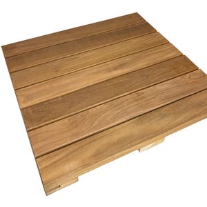 May include: A square wooden deck tile composed of parallel, light brown planks. The wood grain is visible, and the tile is designed for outdoor use. The tile is made of natural wood and has a warm, inviting appearance.