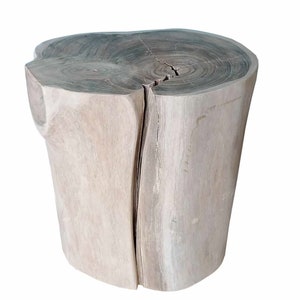 May include: A natural wood stool with a light brown finish and a unique, irregular shape. The top of the stool is a circular slice of wood with visible grain patterns.