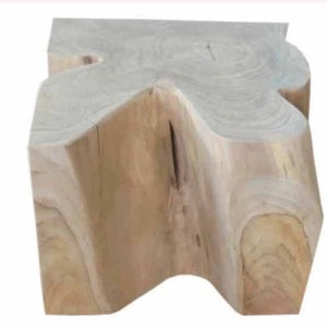May include: A natural wood stool with a unique, organic shape. The stool is made from a single piece of wood and has a natural, rustic finish.