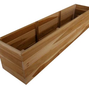 May include: A rectangular wooden planter box with a natural wood finish. The box is divided into three sections and is constructed from light brown wooden planks. The planter is empty and ready for plants.