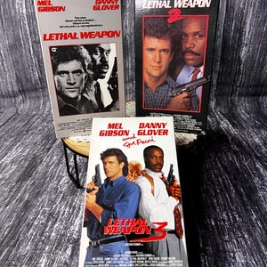 May include: Three VHS tapes of the "Lethal Weapon" movie series. The tapes feature Mel Gibson and Danny Glover on the covers. The first tape is titled "Lethal Weapon", the second "Lethal Weapon 2", and the third "Lethal Weapon 3".