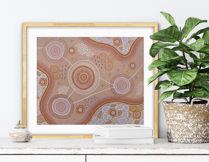 Pode incluir: Impress&atilde;o de arte abstrata em uma moldura dourada. A obra apresenta um fundo bege com padr&otilde;es circulares e lineares marrons, roxos e brancos. A impress&atilde;o &eacute; exibida em uma superf&iacute;cie branca com uma planta em uma cesta tecida.