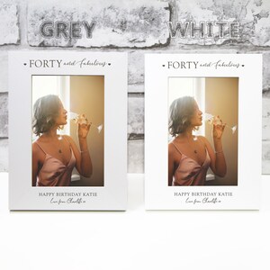 Op de afbeelding: Twee witte fotolijsten met een foto van een vrouw die champagne drinkt. De tekst op de lijsten luidt "FORTY and fabulous." en "HAPPY BIRTHDAY KATIE Love from Charlotte".