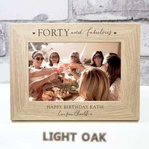 Op de afbeelding: Een fotolijst van licht eikenhout met een gepersonaliseerd bericht dat "FORTY and fabulous" en "HAPPY BIRTHDAY KATIE Love from Charlotte xx" luidt.