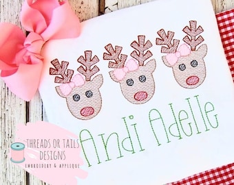 May include: White onesie with three embroidered reindeer faces with pink bows and the name "Andi Adelle" in green thread.