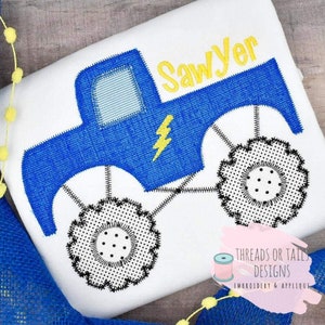 Peut inclure: Une applique de camion monstre bleu avec des roues noires et un éclair jaune. Le nom "Sawyer" est brodé en jaune au-dessus du camion.