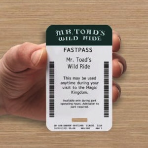 May include: A white and green Fastpass ticket for Mr. Toad's Wild Ride. The ticket has the ride's name and the text "This may be used anytime during your visit to the Magic Kingdom."