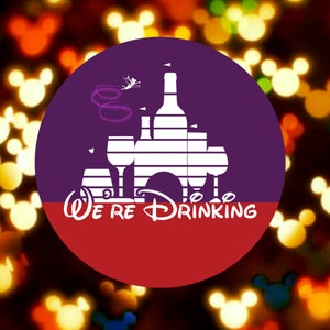 Puede incluir: Un círculo morado y rojo con una silueta blanca de un castillo y copas de vino. El texto "We're Drinking" está debajo del castillo. El fondo es una imagen borrosa de orejas de Mickey Mouse amarillas y naranjas.
