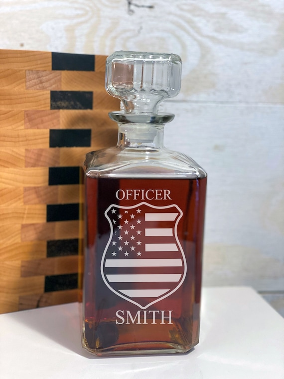 A police-themed whisky decanter engraved with an American flag — niche enough to feel genuinely personal, not just a generic bar accessory.