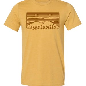 May include: A mustard yellow t-shirt with a brown graphic of a mountain range and the word "appalachia" in a retro font.
