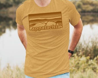 May include: A mustard yellow t-shirt with a brown graphic of a mountain range and the word "Appalachia" printed on the front.