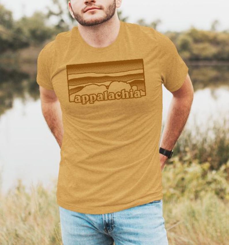May include: A mustard yellow t-shirt with a brown graphic of a mountain range and the word "Appalachia" printed on the front.