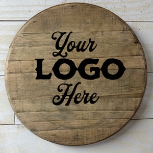 May include: A round wooden sign with a rustic brown finish. The sign has the text "Your Logo Here" printed in black.