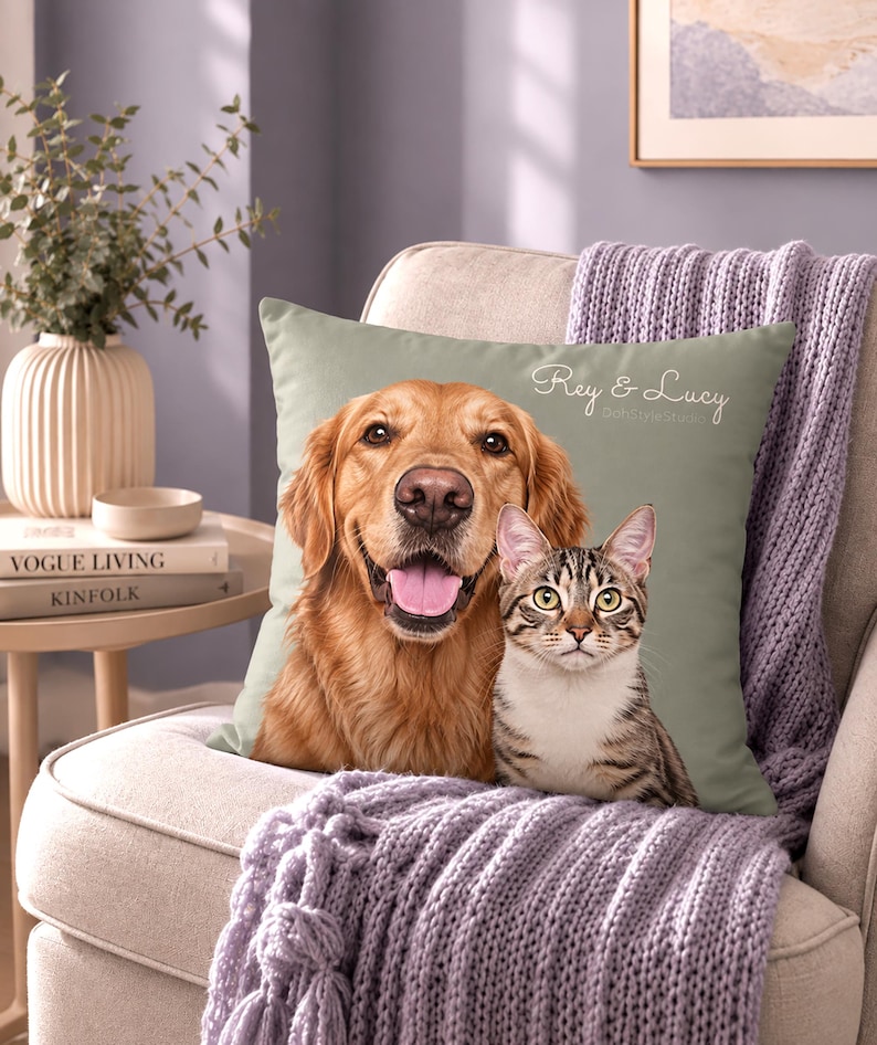 May include: A square sage green throw pillow featuring a printed portrait of a golden retriever and a tabby cat. The text "Rey & Lucy" is printed in white cursive script in the upper right corner of the pillow cover, which is placed on a chair.