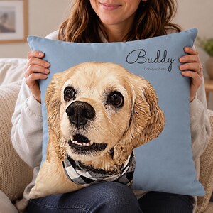 May include: A square light blue throw pillow featuring a detailed illustration of a golden-colored dog with floppy ears and a black and white checkered bandana. The name Buddy is printed in black script above the dog, with DohStyleStudio below.