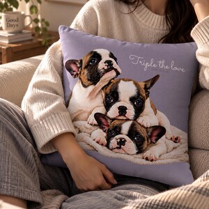 May include: A square lavender throw pillow featuring a printed graphic of three French Bulldog puppies stacked on top of each other on a white blanket. The text Triple the love is printed in white cursive script in the upper right corner.