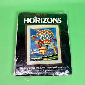 May include: A Monarch Horizons longstitch kit featuring a colorful hot air balloon design with a rainbow. The text reads "ALWAYS CHASING RAINBOWS". The finished size is approximately 16" x 20" (41cm x 51cm).
