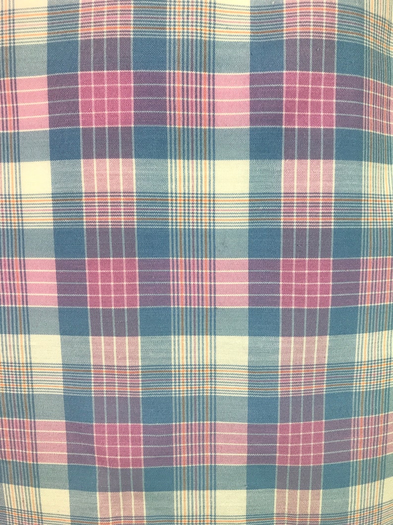 Op de afbeelding: Een stof met een ruitpatroon in tinten blauw, roze en cr&egrave;me.