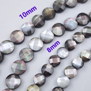 Può includere: Una collana di perle di conchiglia nere e bianche con un bagliore iridescente. Le perle sono rotonde e hanno un design sfaccettato. Le perle sono di 10 mm e 8 mm.