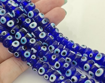 May include: A strand of blue glass beads with white and black evil eye charms.